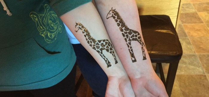 Sarah Glaser henna painting of matching giraffes during birthday party in Anchorage Alaska. 